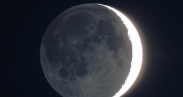 Le côté sombre de la Lune avec de la lumière reflétée par la Terre