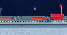 Unterschiedlich schwere Gegenstände werden mithilfe einer Feder voneinander weggestoßen