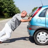 Man die een auto duwt
